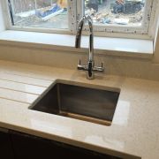 A sparkling ST Quartz Bianco Sparkle worktop with an undermount steel sink, integrated drainer grooves, and a matching stone window sill