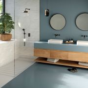 Silestone Cala Blue solid surface worktop and floor, paired with a floating wooden vanity and marble-effect shower walls