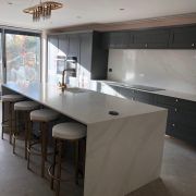 A sophisticated kitchen design pairing dark shaker cabinets with Nile Quartz Calacatta Gold worktops