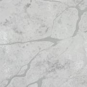 Detailed close-up of ST Quartz Crema Ice, showcasing the complex texture of cloudy grey mottling and fine, cracked veins on a cool, icy white base