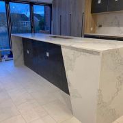 Expertly fabricated kitchen island in ST Quartz Everest, featuring angled, mitred waterfall ends that continue the mountain-range pattern seamlessly