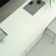 A minimalist kitchen island with a Nile Quartz Ice White worktop, featuring a flush hob and undermount sink