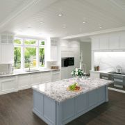 A luxurious kitchen installation featuring a large blue-grey island topped with a statement Nile Quartz Lavender worktop
