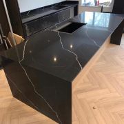 Stunning kitchen island with a waterfall end, crafted from ST Quartz Nero Marquina to showcase its dramatic white veining on a black background