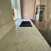A newly installed ST Quartz New Carrara worktop featuring custom-routed drainage grooves alongside an undermount sink.