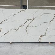 Full slab of ST Quartz Oro Extra, a luxurious Calacatta Gold style quartz featuring bold, golden-brown veins and subtle grey accents on a crisp white background