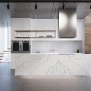 A luxury kitchen featuring a bookmatched Nile Quartz Statuario waterfall island