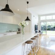 Bright, open-plan kitchen featuring a long breakfast bar with a subtle white Silestone Ariel quartz worktop.