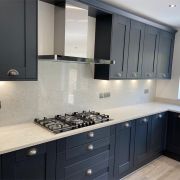 A beautiful, high-contrast kitchen pairing dark shaker cabinets with a detailed Nile Quartz Calacatta Exotic worktop