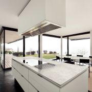Luxury minimalist kitchen featuring a large island with a Nile Quartz Concrete Earth waterfall worktop