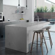 Nile Quartz Concrete Oyster used to create a thick, seamless waterfall worktop on a large kitchen island, with the same material continuing onto the splashback