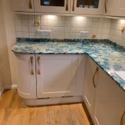 A kitchen installation by S T Stoneworks featuring a vibrant Nile Quartz Emerald Green worktop, fitted on traditional cream cabinets